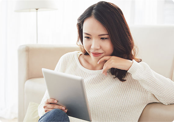 Lady sitting on couch using tablet
